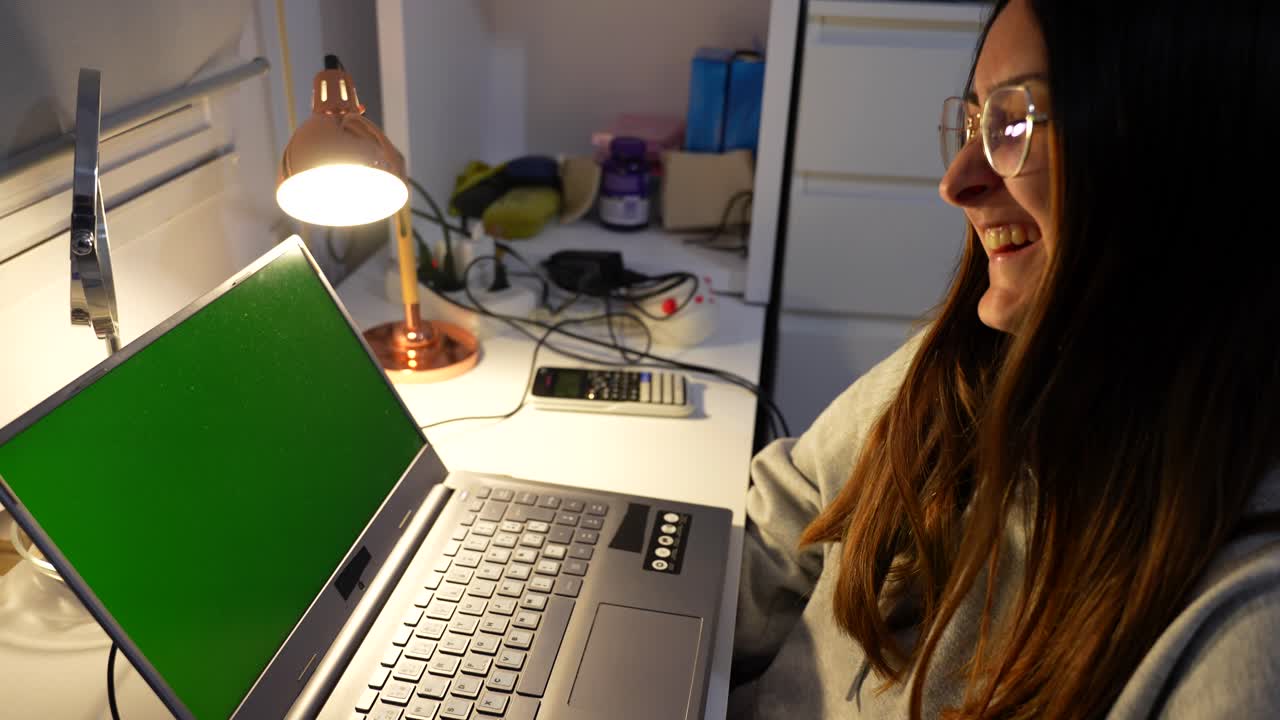 pantalla verde en el portátil de la mujer linda riendo y saludando a la persona en la llamada de video, listo para teclado