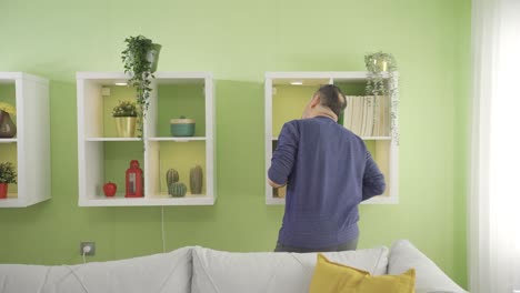 Middle-aged-man-using-cloth-to-clean-furniture-and-floor-in-living-room.