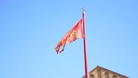 flag of venice with golden winged lion is moving in wind on sunny day