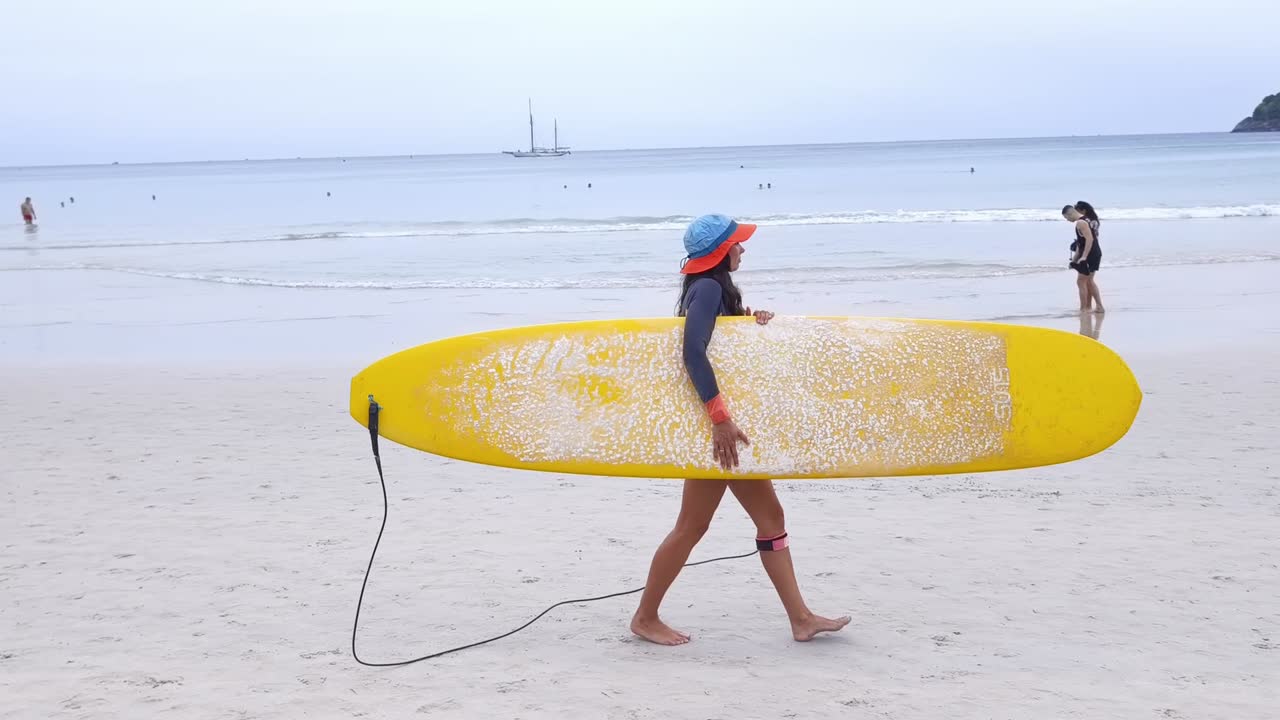 mujer llevando una tabla de surf en una playa