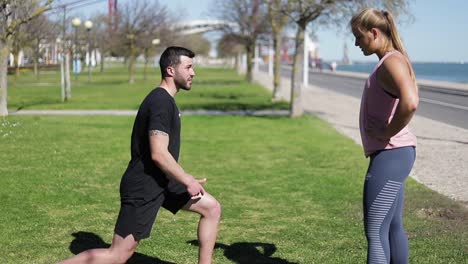 attractive young young woman with personal trainer in park.