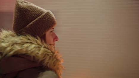 first-person view of a woman in a winter coat with a fur hood, looking left then right as a truck passes in front of her. blurry cars in motion are visible in the background