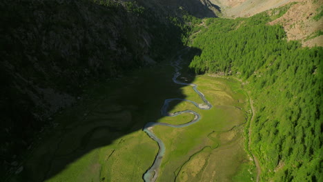 Aerial-drone-view-of-Predarossa-plain-and-Duino-river-flowing-in-summer-season-in-Val-Masino,-Italy