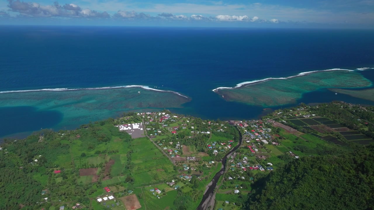 Città di Teahupoo Tahiti Polinesia Francese, ripresa aerea con drone, costa montuosa, mattina soleggiata, cielo blu, baia, barriera corallina, Papeete, Olimpiadi di Parigi 2024, surf, surfista, sede del surf, nuova torre dei giudici, ponte pedonale, panoramica in avanti.