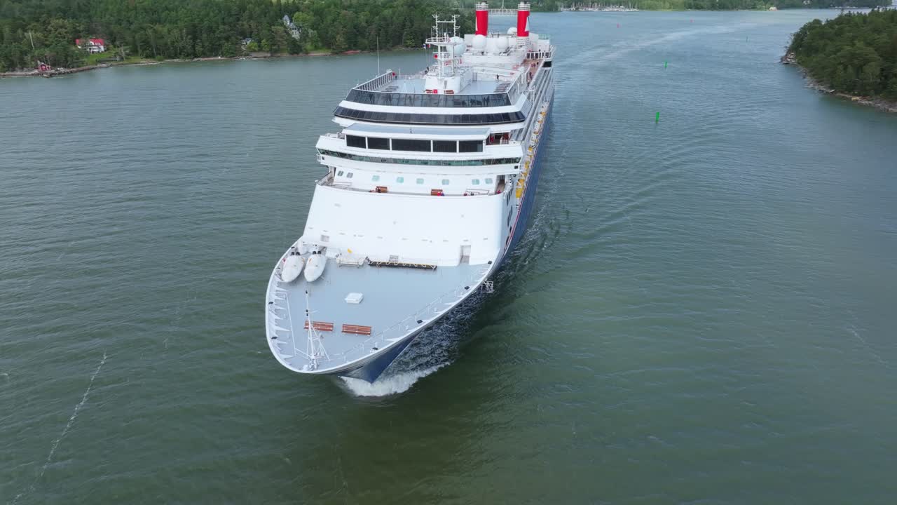 Fred.Olsen Cruise Lines passenger ship BOREALIS making way ahead in Finnish archipelago on departure. Low altitude aerial view crossing bow.