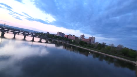 Speed-flight-over-tracks-with-bridges-in-american-town-at-sunrise