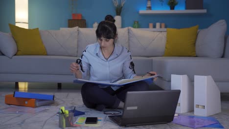 Home-office-worker-woman-smiling-at-camera-looking-at-paperwork.