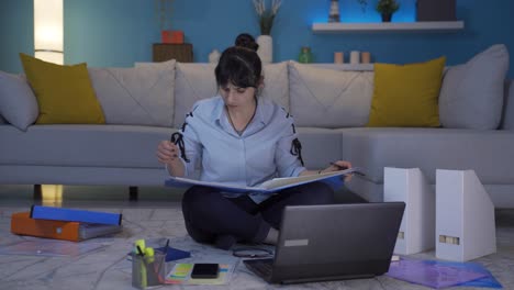 una mujer trabajadora de oficina en el hogar sonriendo a la cámara mirando el papeleo.