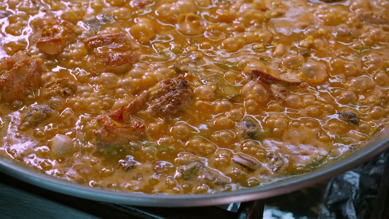 primer plano de una paella con arroz hirviendo