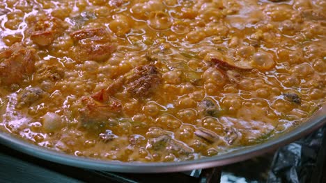 primer plano de una paella con arroz hirviendo