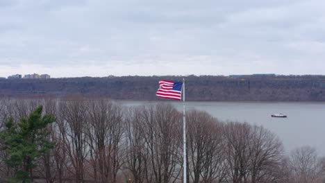 american flag waving in the wind with george washington bridge in background