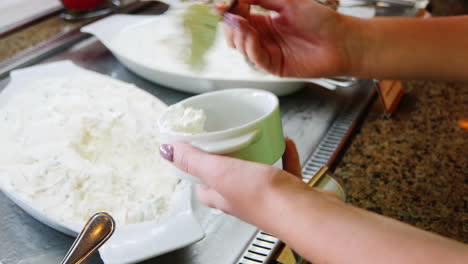 take the sliced cucumbers on the plate and watering sauce in the cafe with self-service