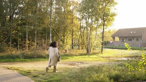 curly woman taking a walk in nature during autumn