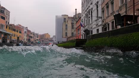 Water-surface-pov-of-Venice-seen-from-sailing-boat-with-Ponte-Delle-Guglie-bridge-in-background,-Italy