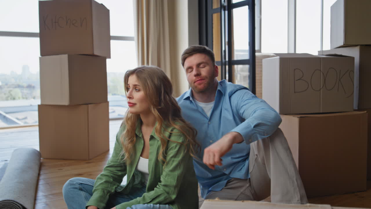 Exhausted spouses moving apartment feeling stress. Fatigued homeowners rest