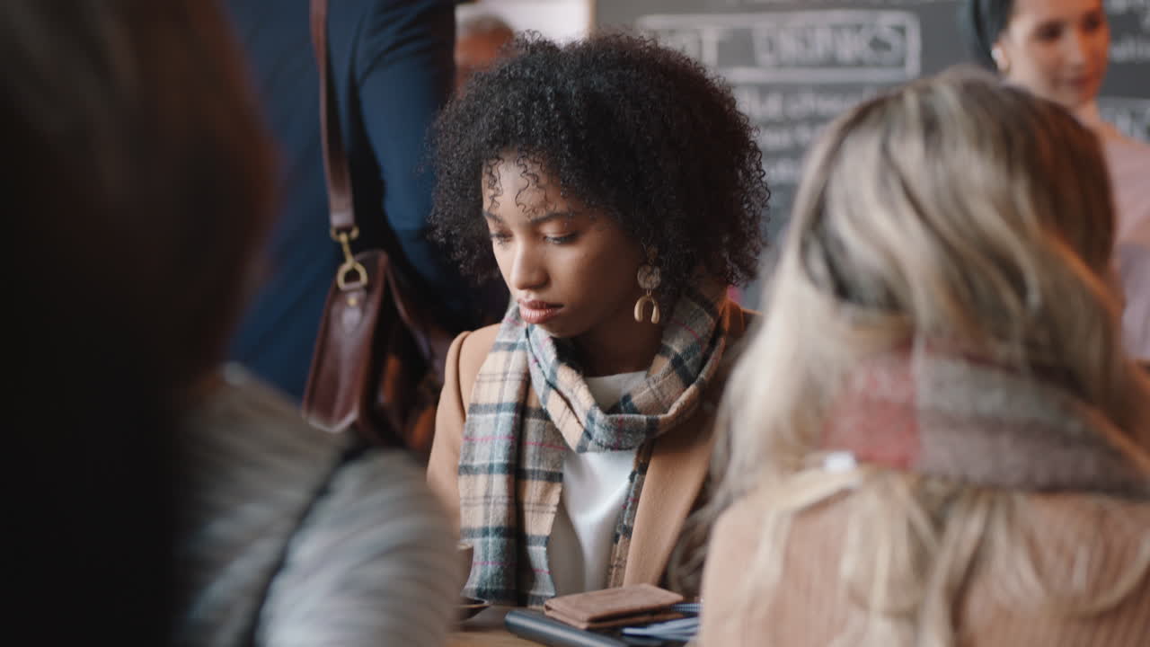 hermosa mujer afroamericana usando un teléfono inteligente en un café enviando mensajes de texto compartiendo mensajes en las redes sociales disfrutando de la tecnología móvil en un restaurante ocupado