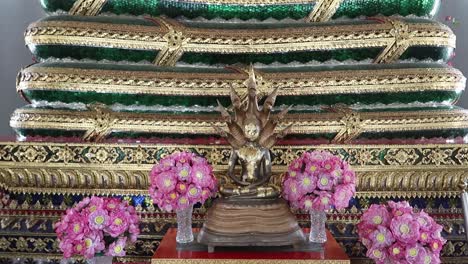 gilded saturday buddha protected by naga multi-headed snake at wat pho, bangkok