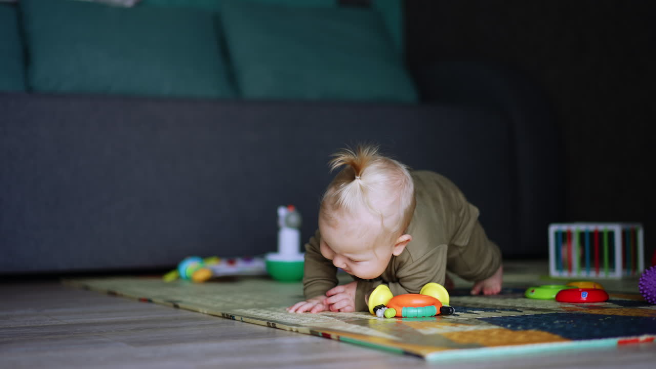 Caucasian baby boy lying on the floor tries to stand up but fails. Lovely child starts to cry bitterly.