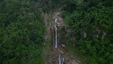 push forward towards a tall waterfall surrounded by dense jungle