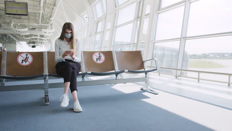 woman wearing mask waiting at airport