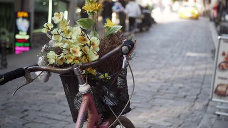 pink bicycle with flowers in basket