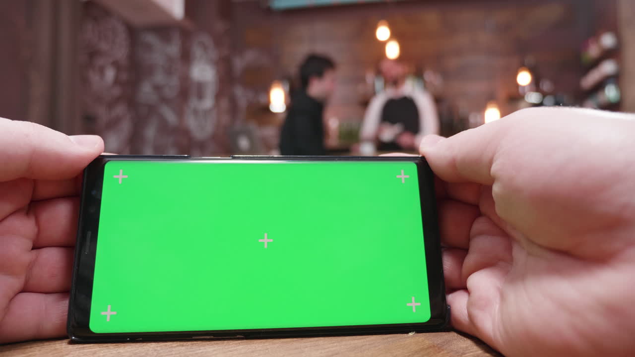 Smartphone with green screen in a bar