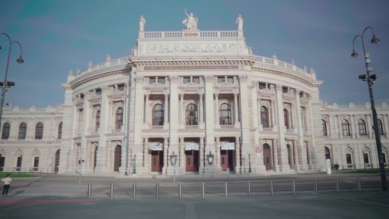 Motion tilt up over empty street around historic Burgtheater, Austria