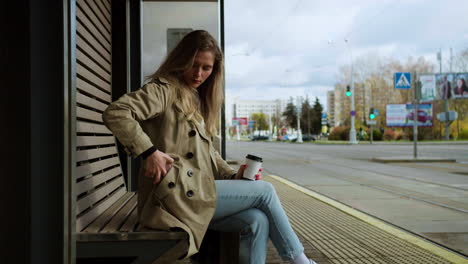 Young-woman-sitting-at-bus-stop