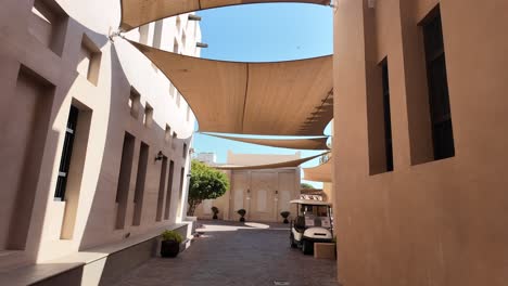 alleyway in a middle eastern quarter with canopies and golf cart