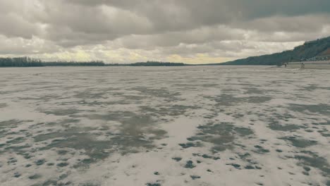 Movimiento-Sobre-Nieve-Sucia-Marrón-Y-Hielo-En-La-Superficie-Del-Agua-Del-Río