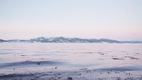 Seascape-With-Calm-Waves-And-Snowy-Mountains-In-Background-Near-Vanvikan,-Indre-Fosen,-Norway