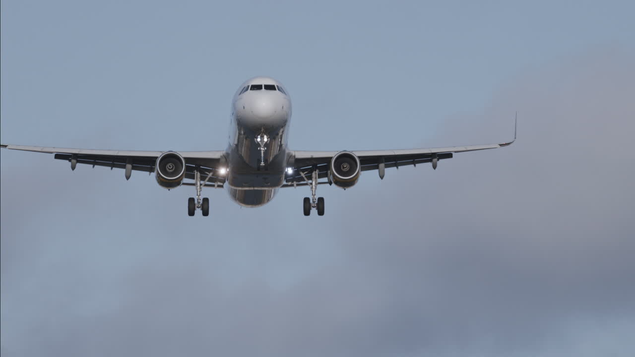 Avión volando en el cielo para aterrizar en el aeropuerto a cámara superlenta al atardecer