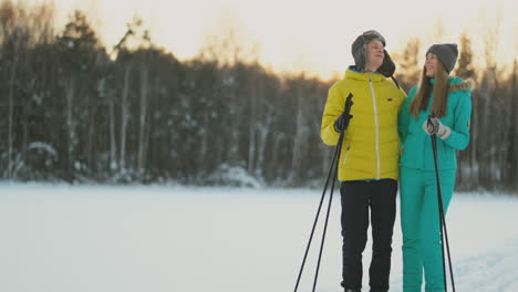 en el bosque de invierno al atardecer, una pareja amante de esquiar y contemplar la belleza de la naturaleza y las atracciones en cámara lenta.