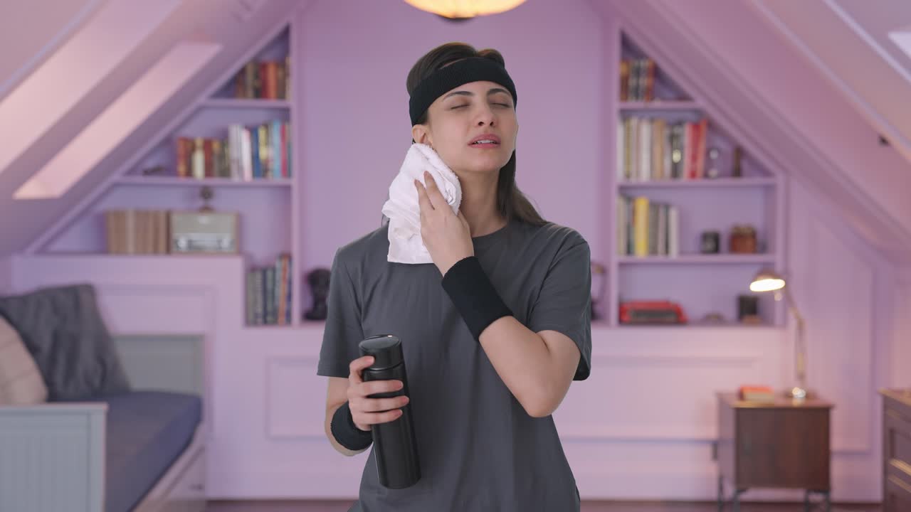 mujer india limpiando el sudor y bebiendo agua