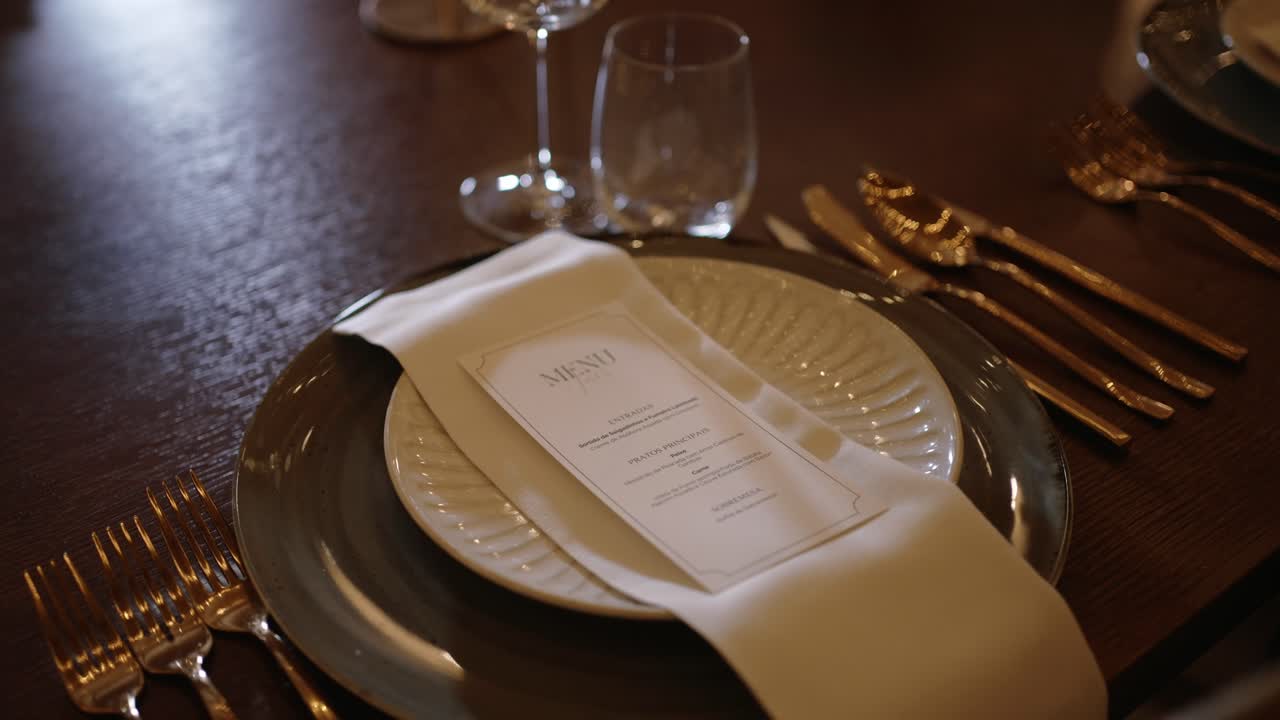 금색 커틀러리, 냅킨, 인쇄된 메뉴 카드와 함께 클로즈업된 웨딩 테이블 세팅