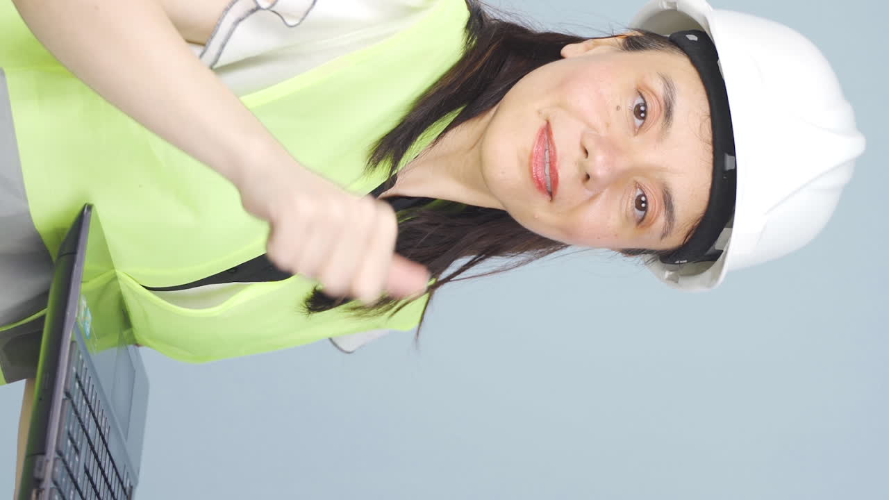 ⁇ 탑을 들고 카메라를 보며 웃는 엔지니어의 수직 비디오.