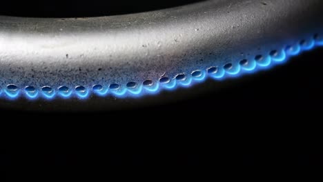 quemador de gas en el horno de primer plano en un fondo negro. video crudo macro 4k.