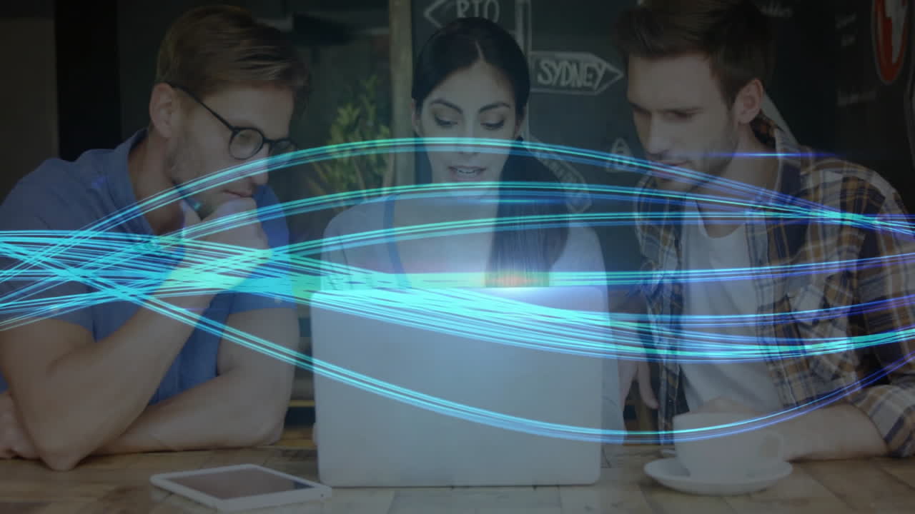 Three colleagues leaning and focusing on laptop screen in business meeting with blue light streaks