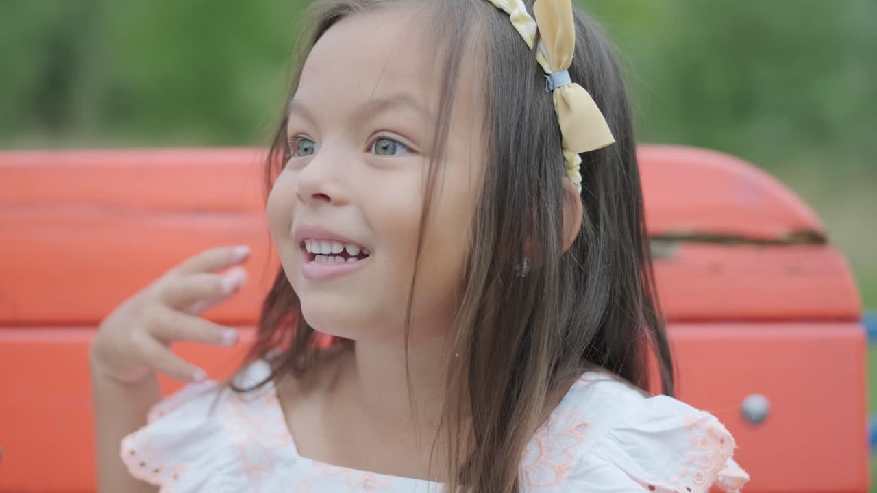 una madre embarazada y su hija joven disfrutan de un tiempo de juego juntos en un patio de recreo en el parque, rodeados de árboles y vegetación