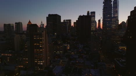 Elevated-ascending-footage-of-tall-office-or-apartment-buildings-in-city,-silhouettes-of-skyscrapers-against-twilight-sky.-Manhattan,-New-York-City,-USA