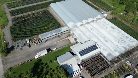 aerial drone shot of industrial commercial glasshouses growing food