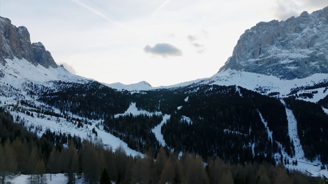 Vista mozzafiato della Val Gardena, Dolomiti, con pittoresche foreste di conifere e alte rocce dolomitiche.