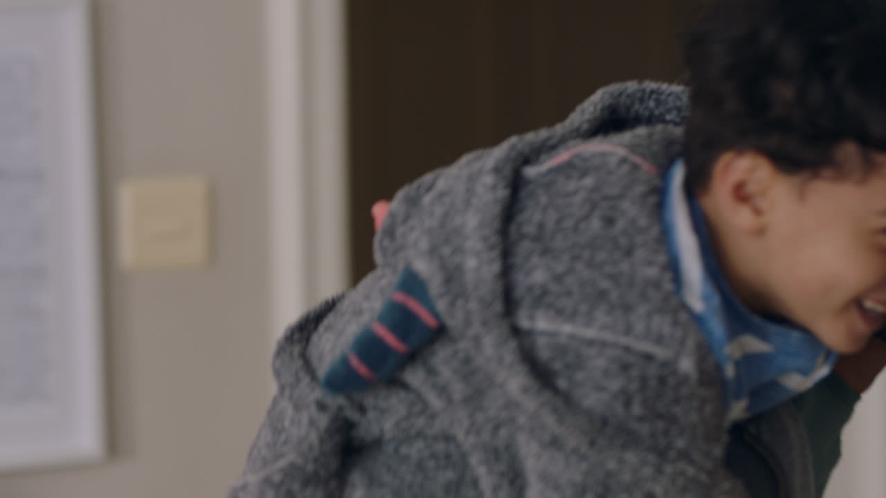 행복한 작은 소년은 아버지의 등으로 뛰어들어 아버지와 함께 놀고 집에서 아들과 함께 장난스러운 게임을 즐기고 있습니다.