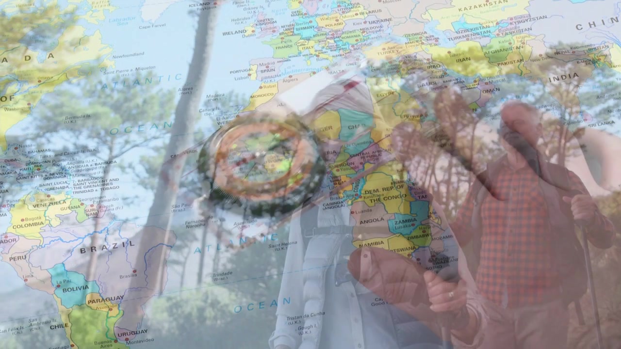 Male hiker bringing compass forward and checking heading, world map overlay guiding navigation