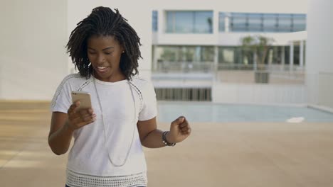 smiling young woman happy to hear good news outdoor.