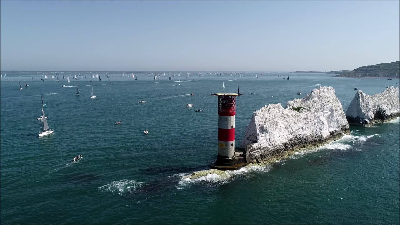 las agujas, los acantilados y el faro fotografiados con veleros al fondo