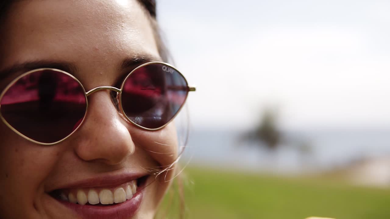 cerca linda morena sensual chica lamiendo helado en un cono - cucharas blancas y amarillas. mientras mira a la cámara y sonriendo. capturado en vista lateral. verde al aire libre