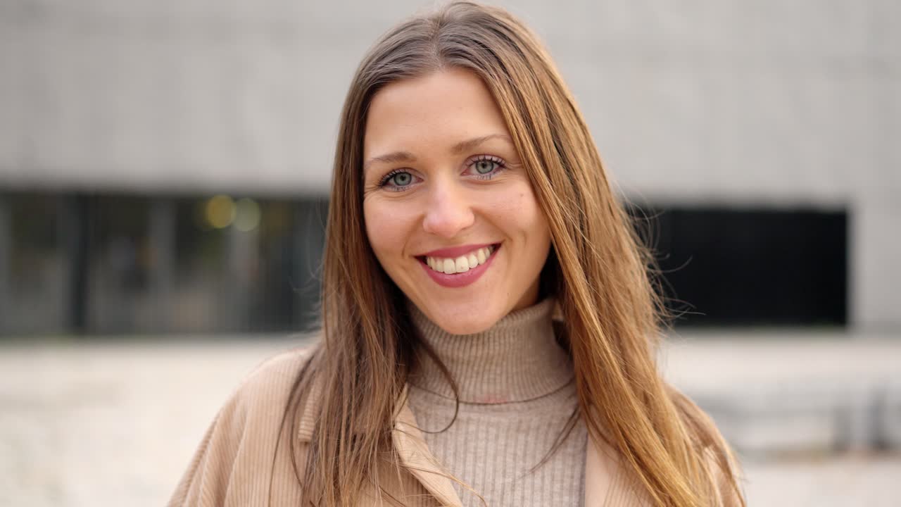 Young female student smiling at camera outdoors