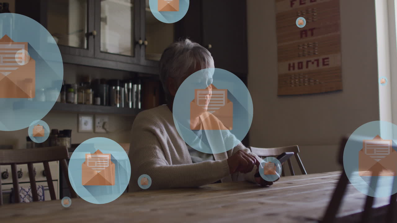 Animation of envelope icons in circles over senior biracial woman scrolling on smartphone at home