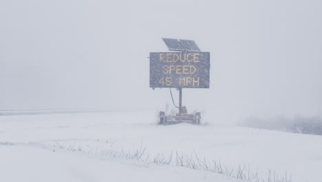 reduce speed road sign warning during whiteout blizzard on i-295 in freeport, maine